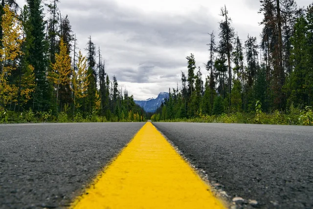 highway, wilderness, yellow line, asphalt, landscape, travel, road, forest, mountains, woods, discover, nature, outdoors, journey, adventure, summer, explore, sky, scenic, route, destination, holiday, roadtrip, vacation, trip, horizon. How to build an NEMT scheduling system that works backward from arrival